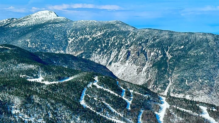 Smuggs showing it's notch with Mt. Mansfield in the background.  📷 Smugglers' Notch